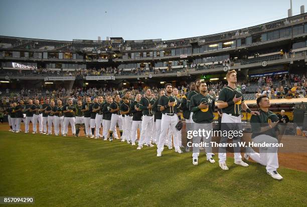 Bruce Maxwell of the Oakland Athletics kneels in protest next to teammate Mark Canha duing the singing of the National Anthem prior to the start of...