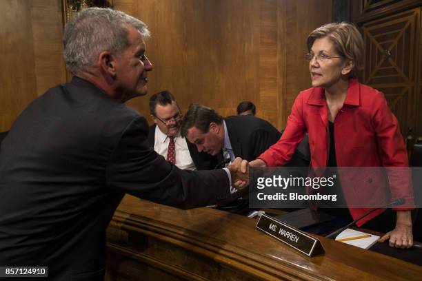 Tim Sloan, chief executive officer and president of Wells Fargo & Co., shakes hands with Senator Elizabeth Warren, a Democrat from Massachusetts,...