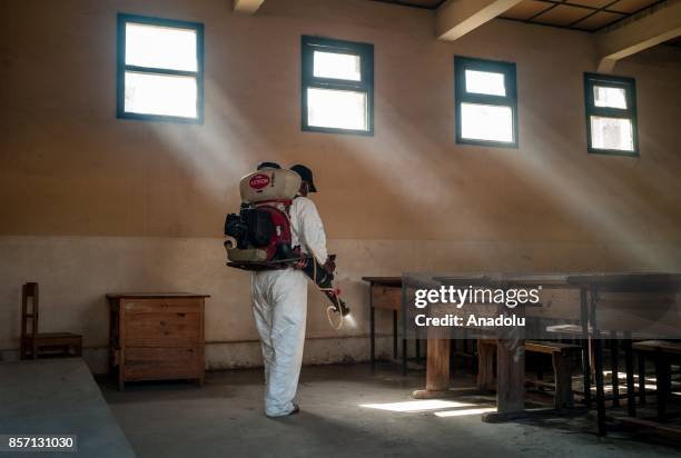 Workers from Department of Emergency and Response to Epidemics and Disasters within the Ministry of Health of Madagascar implement a desinsectisation...