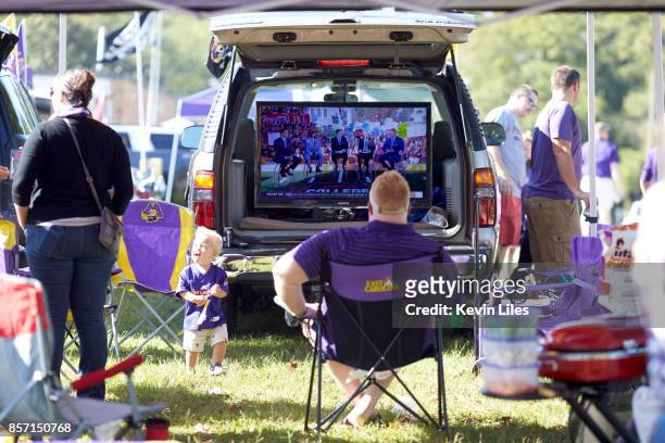 View of East Carolina fans tailgating before game vs South Florida outside of Dowdy-Ficklen Stadium. Fan watching pregame show on big screen in the...
