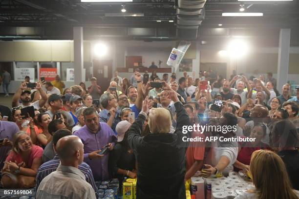 President Donald Trump takes part in a food and suplly distribution at the Cavalry Chapel in Guaynabo, Puerto Rico on October 3, 2017. Nearly two...