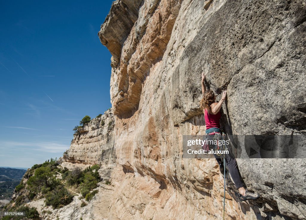 Young woman practicing rock climbing