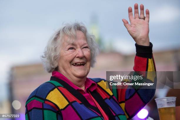 Woman smiles at an amusement area set up along 17th of June Street in Tiergraten Park near the Brandenburg Gate on German Unity Day on October 3,...