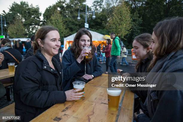Group of women drink beer at an amusement area set up along 17th of June Street in Tiergraten Park near the Brandenburg Gate on German Unity Day on...