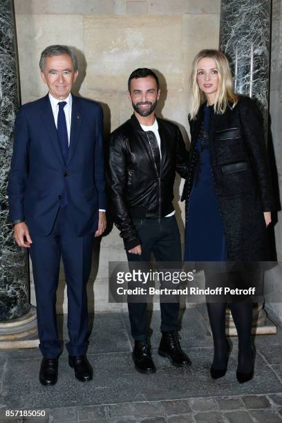 Stylist Nicolas Ghesquiere standing between Owner of LVMH Luxury Group Bernard Arnault and his daughter Louis Vuitton's executive vice president...