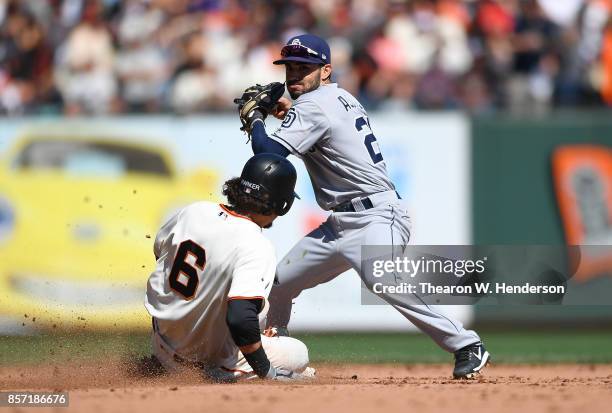 Carlos Asuaje of the San Diego Padres throws to first base over the top of Jarrett Parker of the San Francisco Giants but not in time to complete the...