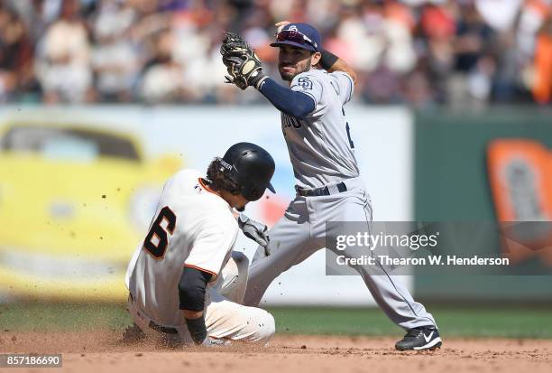 Carlos Asuaje of the San Diego Padres throws to first base over the top of Jarrett Parker of the San Francisco Giants but not in time to complete the...