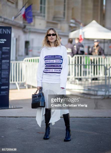 Pernille Teisbaek wearing white Chanel longshirt, skirt, black boots seen outside Chanel during Paris Fashion Week Spring/Summer 2018 on October 3,...