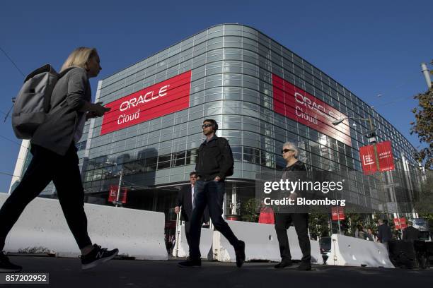 Pedestrians walk in front of the Moscone Center West during the Oracle OpenWorld 2017 conference in San Francisco, California, U.S., on Tuesday, Oct....