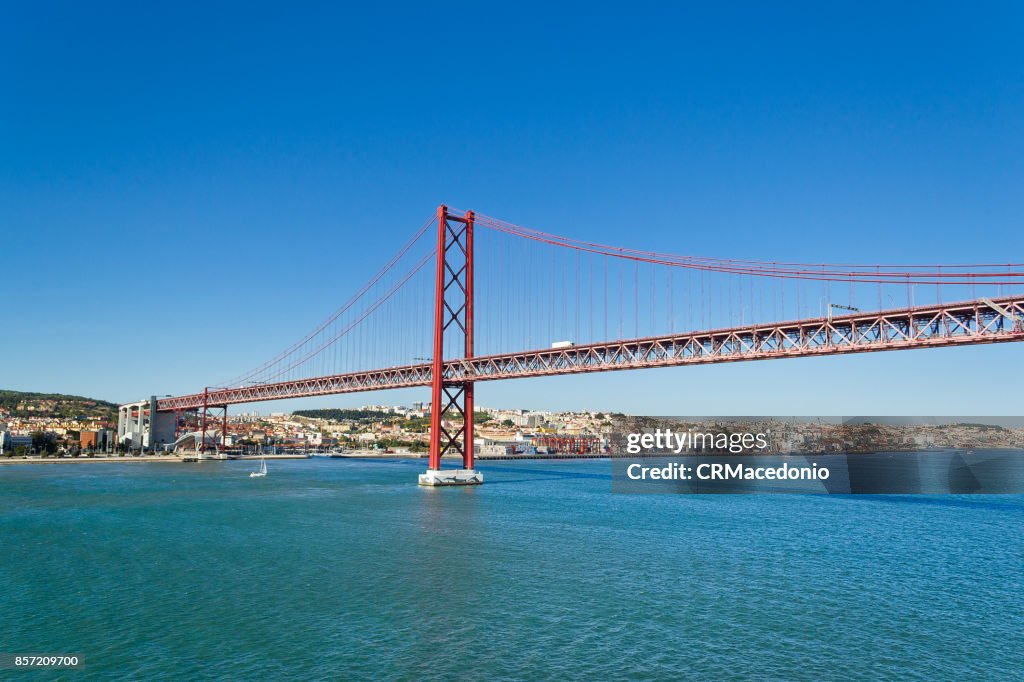 The 25 de Abril Bridge (Ponte 25 de Abril) under Blue sky.