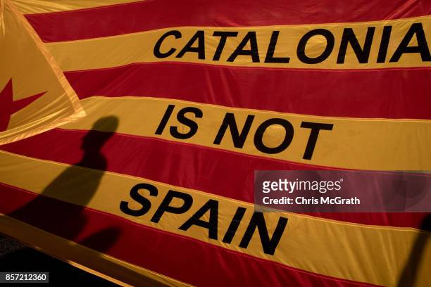 Protesters shadows are seen on a Catalan flag as thousands of citizens gather in Plaza Universitat during a regional general strike to protest...