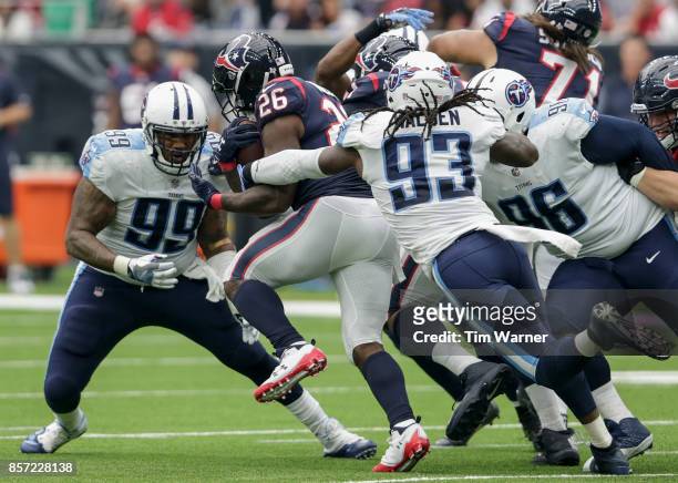 Lamar Miller of the Houston Texans is tackled by Erik Walden of the Tennessee Titans and Jurrell Casey in the first half at NRG Stadium on October 1,...
