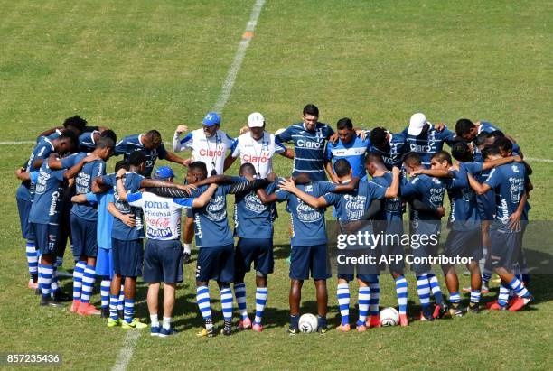 Honduras' coach Colombian Jorge Luis Pinto prays with his players during a training session at the Carlos Miranda stadium, in Comayagua, 80 km north...