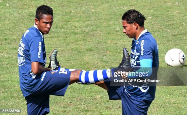 Honduras' players Cristian Altamirano and Carlos "Mango" Sanchez stretch during a training session at the Carlos Miranda stadium, in Comayagua, 80 km...