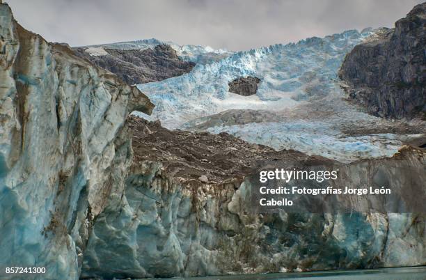 closer view of glacier los leones front blue ice carry out dust and rocks. - aisen del general carlos ibanez del campo stock pictures, royalty-free photos & images