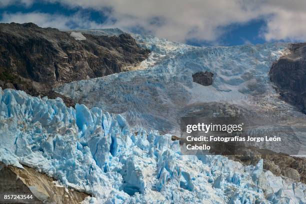 a side view of glacier los leones descending among the mountains. - aisen del general carlos ibanez del campo stock pictures, royalty-free photos & images