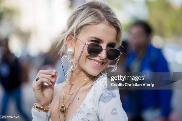 Caroline Daur wearing cropped top, skirt, heart earrings seen outside Miu Miu during Paris Fashion Week Spring/Summer 2018 on October 3, 2017 in...