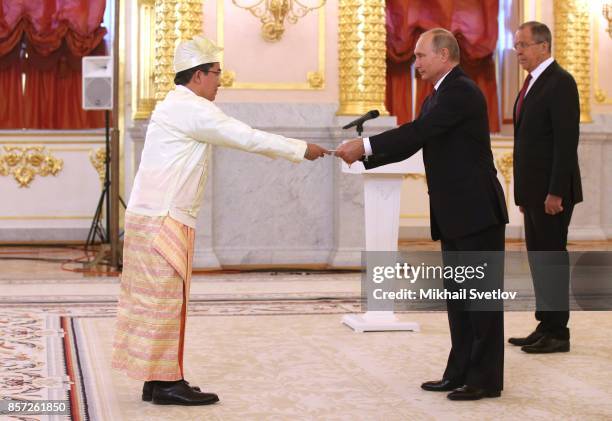 Russian President Vladimir Putin takes credentials from Myanmar's new Ambassador Ko Ko Shein as Foreign Minister Sergey Lavrov looks on during the...