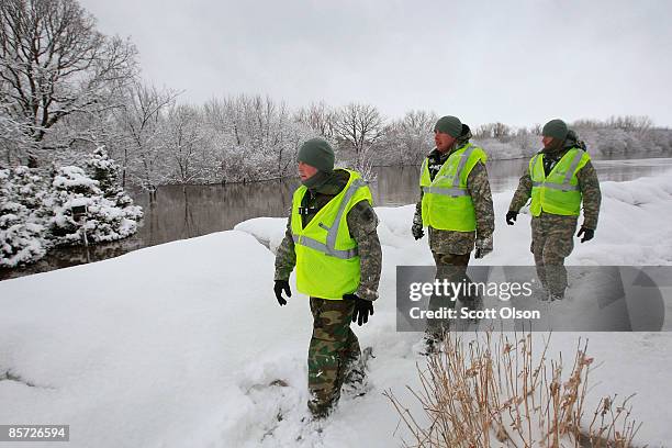 Sgt. Josh Bracken , Spec. Jared Mohelski and Spec. Michael Berman of the North Dakota National Guard inspect a levee along the flooded Red River...