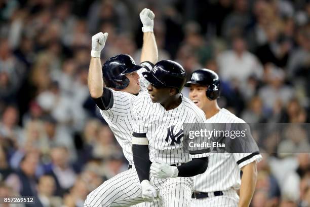 Didi Gregorius of the New York Yankees celebrates with Brett Gardner and Aaron Judge after hitting a three run home run against Ervin Santana of the...