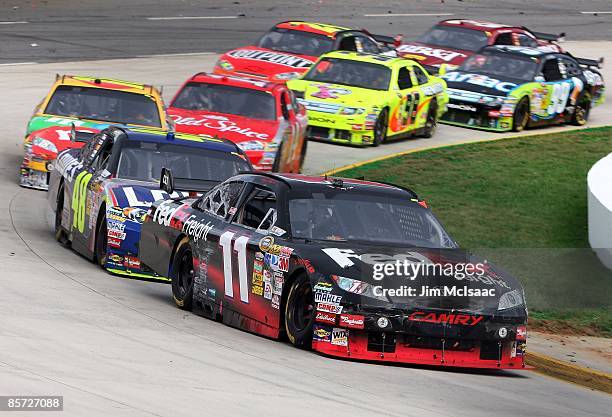 Denny Hamlin, driver of the FedEx Express Toyota, leads a pack of cars during the NASCAR Sprint Cup Series Goody's Fast Pain Relief 500 at the...