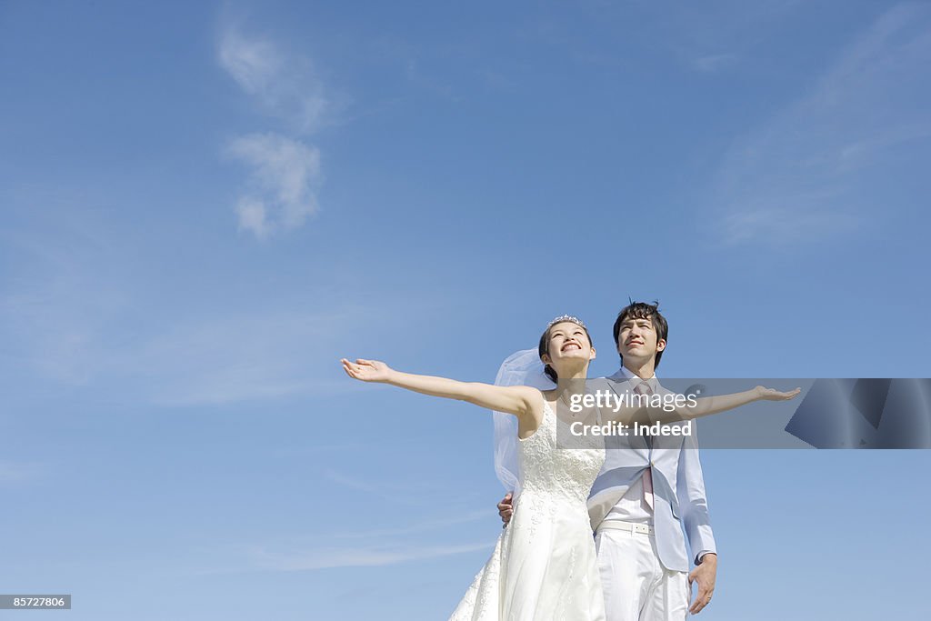 Bride and bridegroom looking up to sky