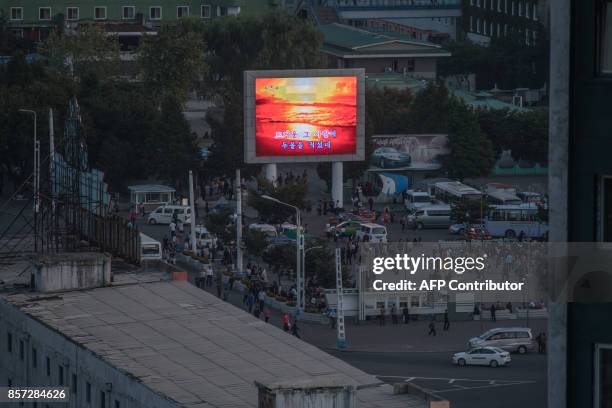 Photo taken on September 23, 2017 shows an image of the sun broadcast on the illuminated screen of a giant television in a public square in...