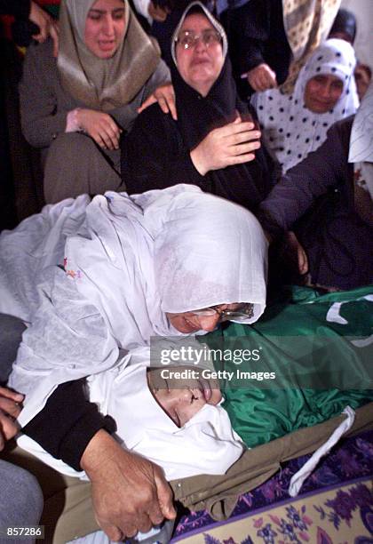 Relative kisses eight-year-old Palestinian girl Ines Saleh at her home during her funeral March 2, 2002 in Jebalya refugee camp in the north of Gaza...