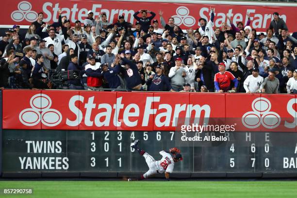 Fans in the outfield cheer as Eddie Rosario of the Minnesota Twins falls to the ground on Aaron Judge of the New York Yankees two run home run...