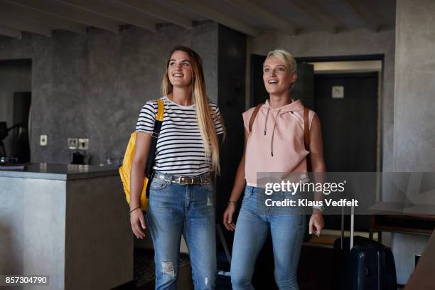 two young woman arriving to urban rental apartment - couple in surprise stock pictures, royalty-free photos & images