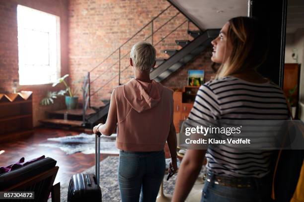 two young woman arriving to urban rental apartment - casa in affitto foto e immagini stock