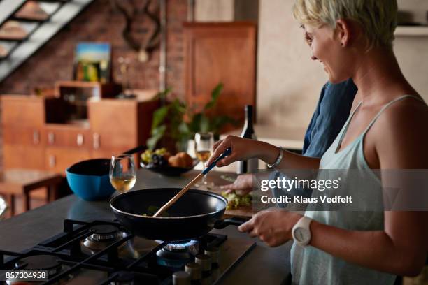 two young women cooking together in loft apartment - gasspis bildbanksfoton och bilder