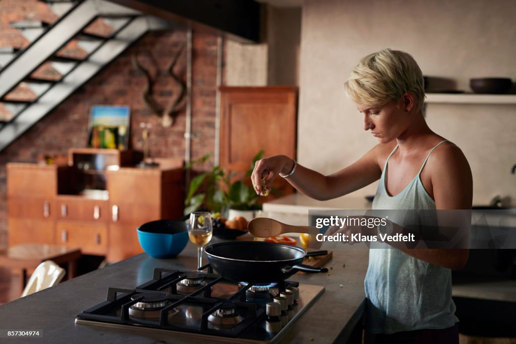 Young woman cooking in loft apartment