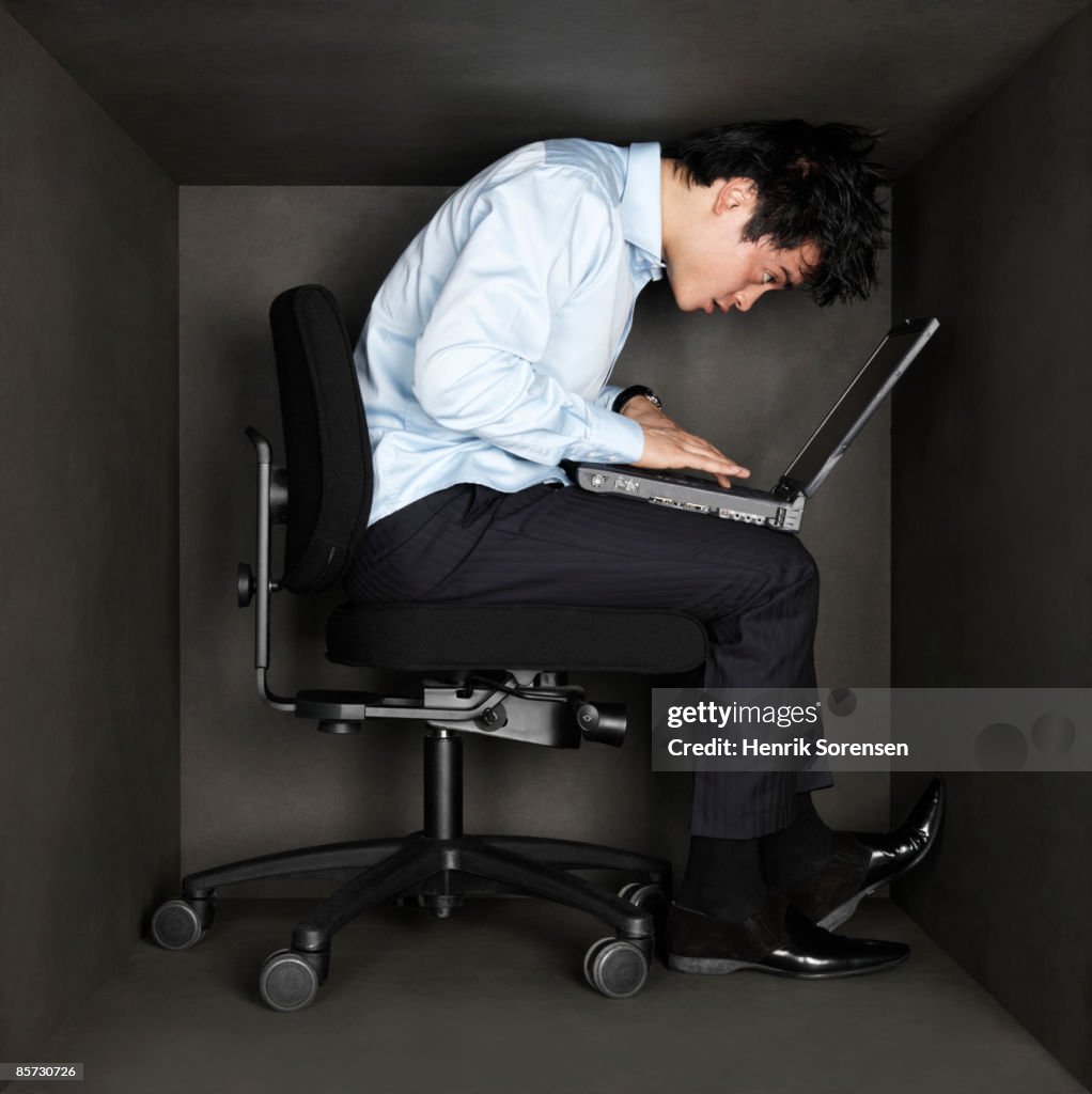 Business man trapped inside a small black room