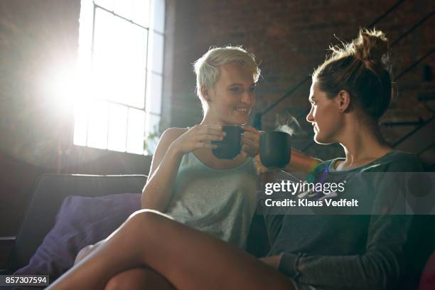 lesbian couple relaxing and drinking tea - hot beverage stock-fotos und bilder