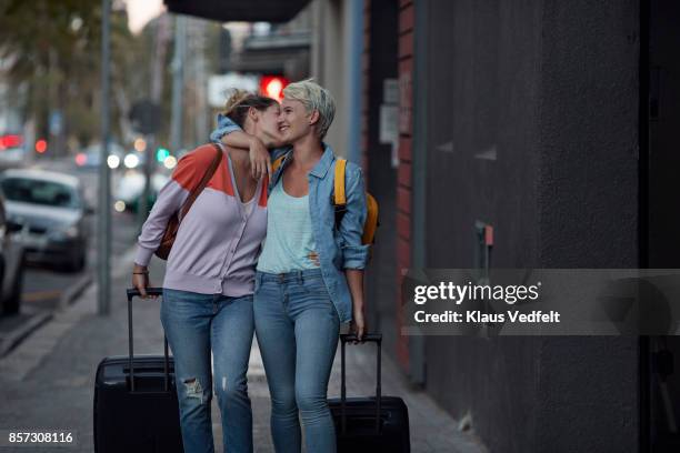 lesbian couple walking together with rolling suitcases - completamente desabotoado imagens e fotografias de stock