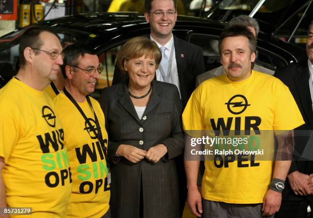 German Chancellor Angela Merkel and workers of carmaker Opel smile during her visit on March 31, 2009 in Ruesselsheim, Germany. Opel is seeking a...