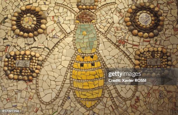 Une abeille et des motifs geometriques dans la maison en vaisselle cassee de Robert Vasseur le 12 septembre 1992 a Louviers, France.