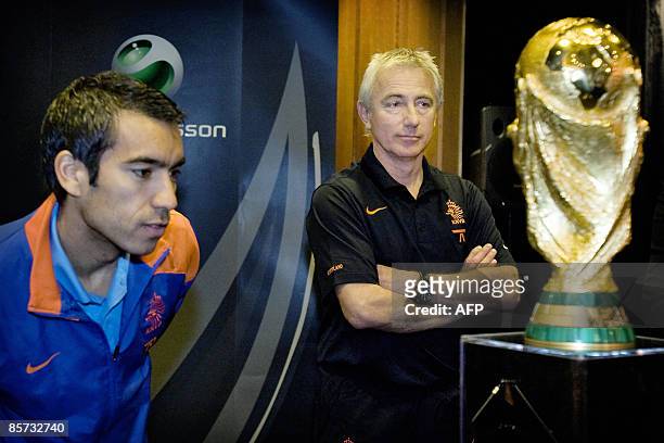 Coach of the Dutch national football team, Bert van Marwijk and team captain Giovanni van Bronckhorst pose with the World cup trophy during a press...