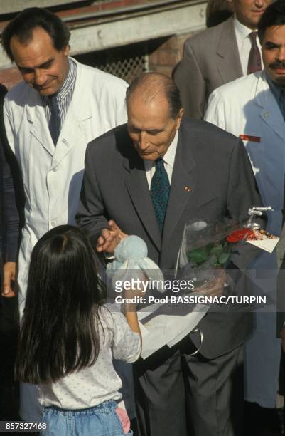 Le president Francois Mitterrand sort de l'hopital Cochin apres son operation de la prostate et recoit une peluche de la part d'une petite fille; a...
