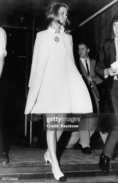 British fashion model Jean Shrimpton in a matching white knee-length dress and coat, Australia, 1965.
