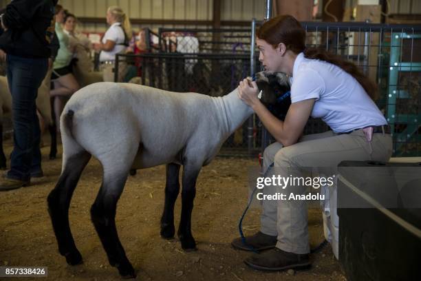 Girl cuddles with her sheep after competing in the 4-H Sheep Show at the Calvert County Fair in Barstow, Md., United States on September 29, 2017....