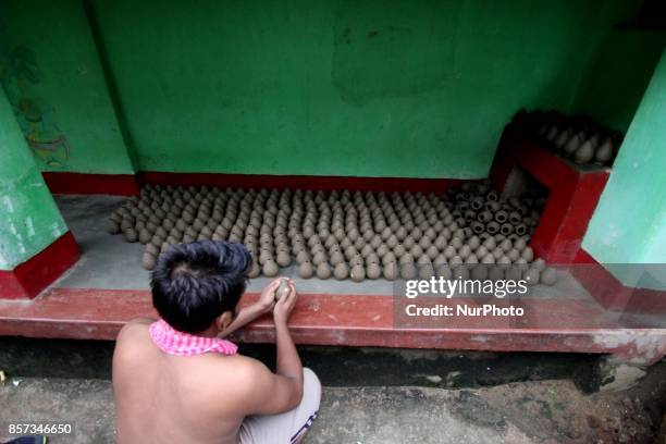 Members of a traditional potter family busy to built fire cracker shells in clay ahead of the festival of lights &quot;Diwali&quot; at a village...