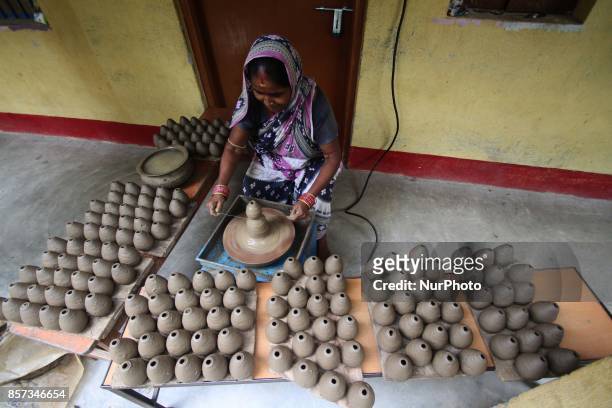 Members of a traditional potter family busy to built fire cracker shells in clay ahead of the festival of lights &quot;Diwali&quot; at a village...
