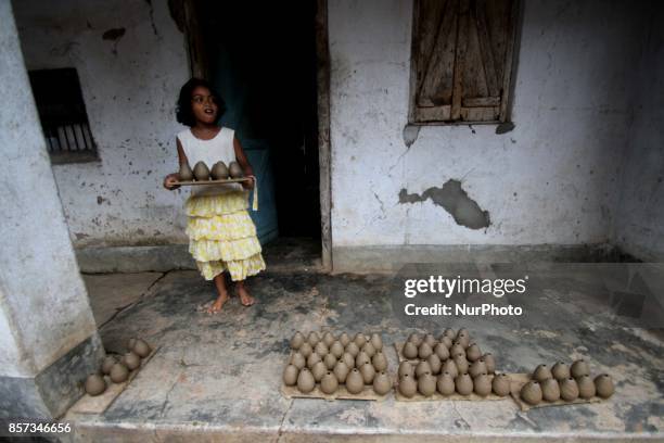 Members of a traditional potter family busy to built fire cracker shells in clay ahead of the festival of lights &quot;Diwali&quot; at a village...