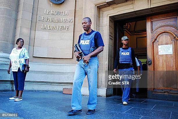South African policemen walk at the exit of the South Gauteng High Court in Johannesburg on March 31, 2009 following the attempted escape by two man...