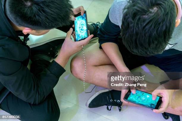 Young players practice the mobile game Arena of Valor, prepared for the battle match held in a shopping mall. Arena of Valor: 5v5 Arena Game, China's...