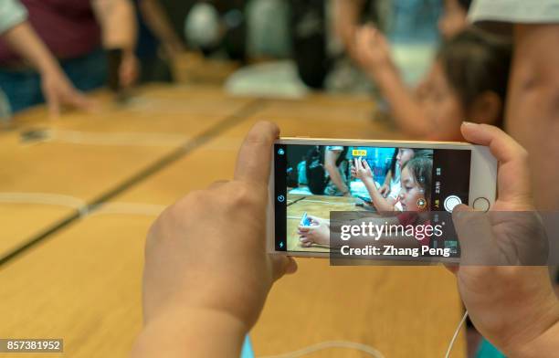 Chinese customers are trying the new iPhone 8 in an Apple store. In Sept., iPhone 8 arrived on the market, but in many Apple retail stores around the...