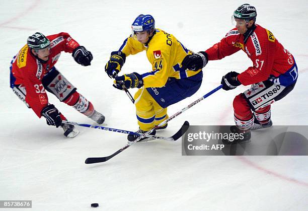 Swiss Ivo Rüthemann , Sweden's Viktor Hedman and Swiss Ryan Gardner competes in the friendly ice hockey match between Sweden's Tre Kronor and...