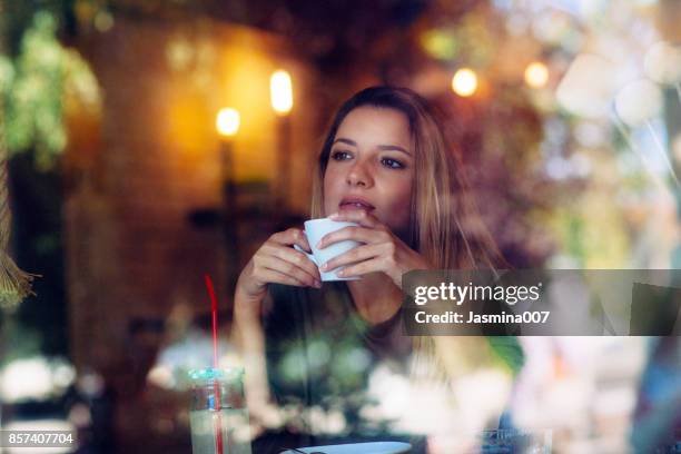 portrait of beautiful young women sitting at the cafe - view-through-restaurant-window stock pictures, royalty-free photos & images